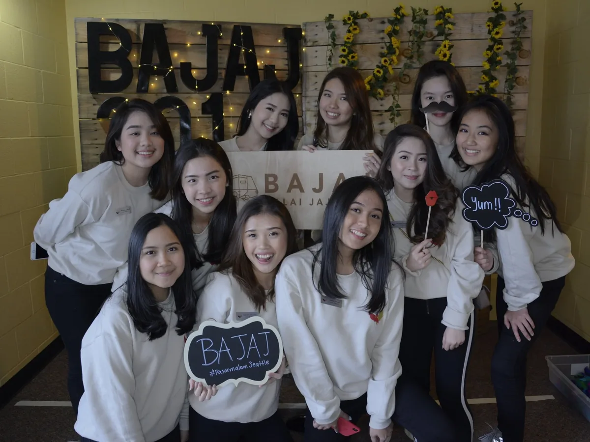 Friends holding BAJAJ props at the festival photo booth