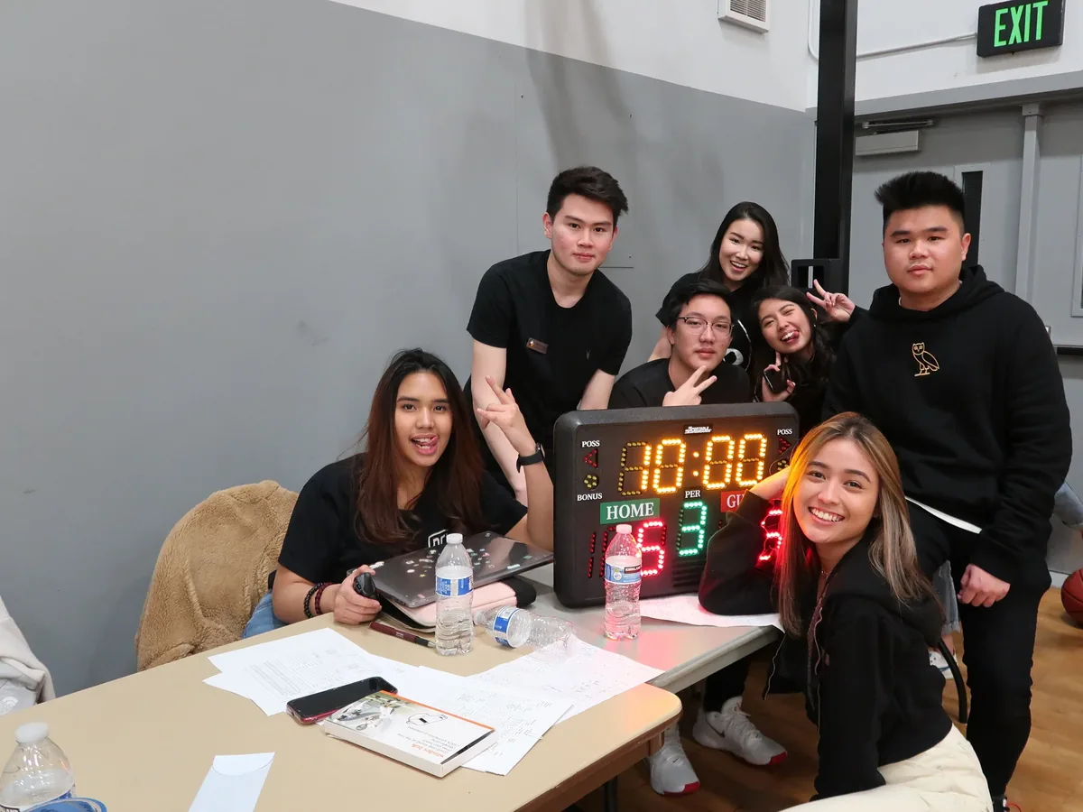 PERMIAS Cup committee smiling behind the scoreboard table