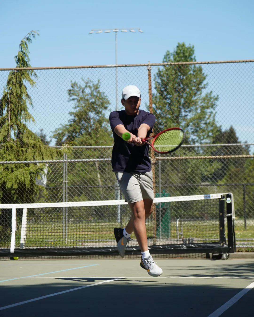 A player hitting a forehand on an outdoor court